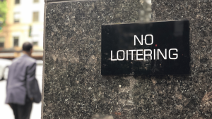 no loitering sign mounted on a marble building