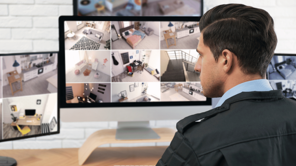 security guard watching camera feeds on computer monitor