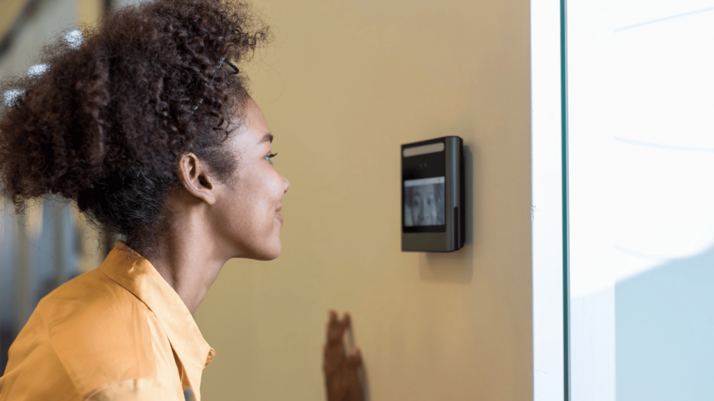 woman looking into a face recognition access control terminal mounted on the wall