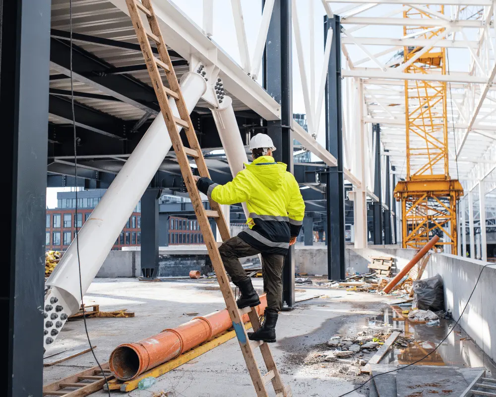 Worker climbing down a ladder at a construction site