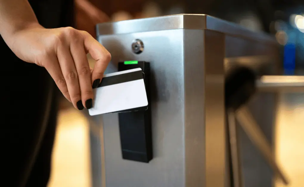 person scanning access card at turnstile card reader