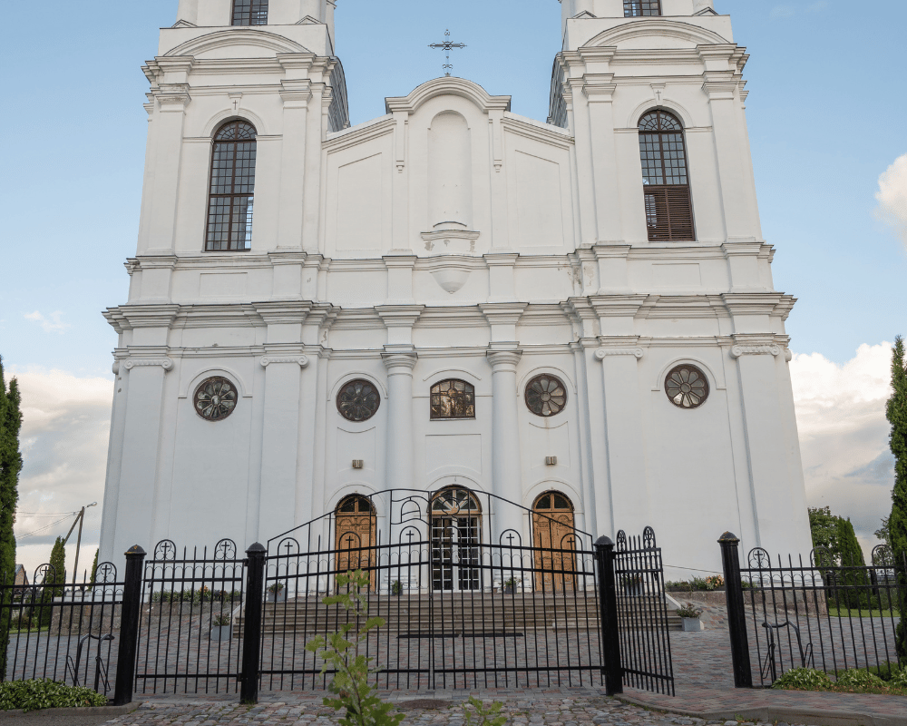 Open iron gate in front of a large white church