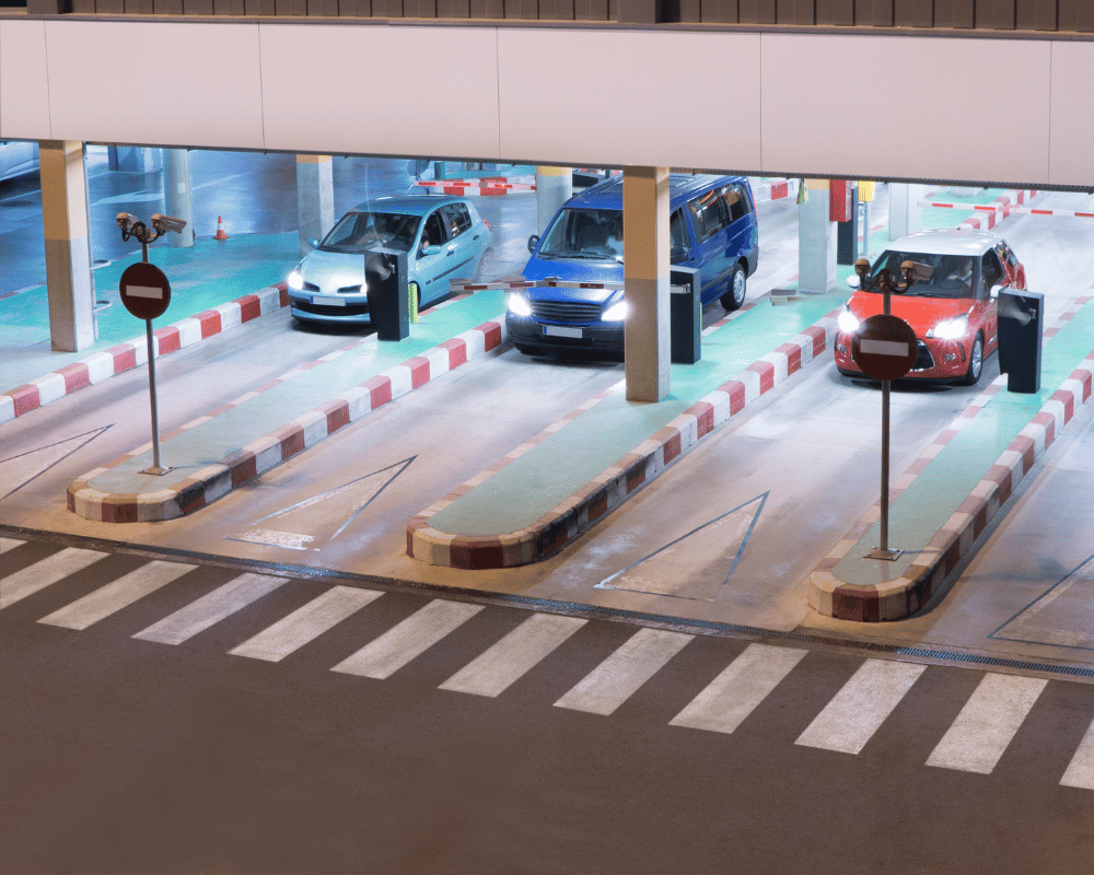 Line of cars exiting parking garage through automatic gate barriers